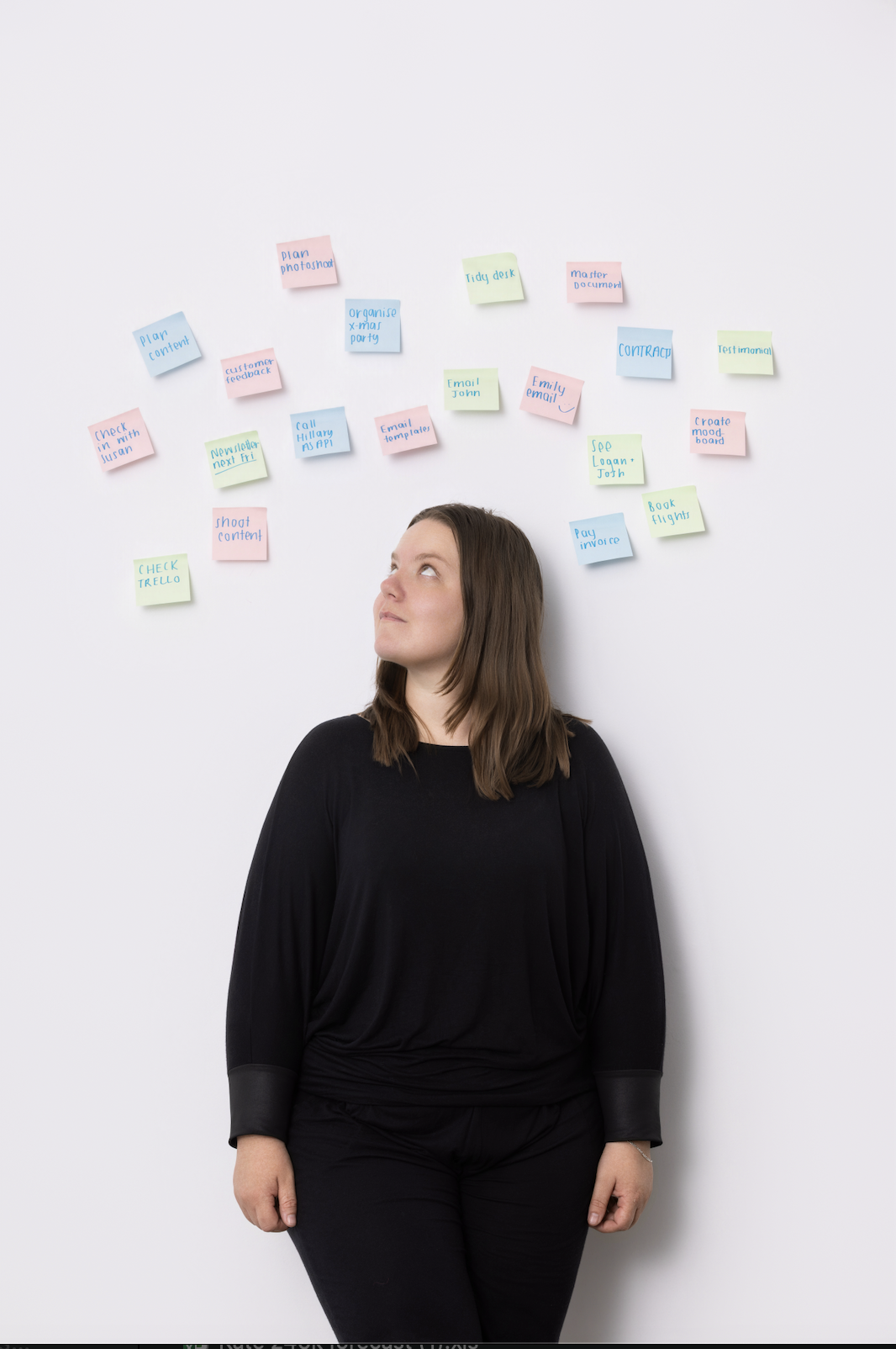Solo marketer surrounded by sticky notes with tasks like check Trello, shoot content, email templates, and customer feedback, illustrating the overwhelm Backkr helps solve
